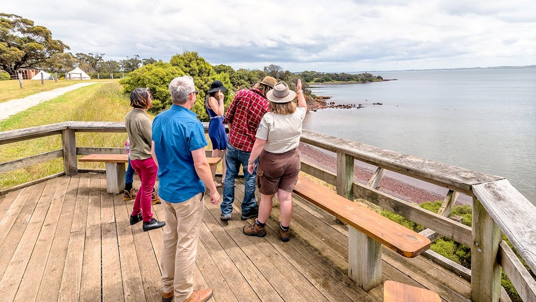 Ranger guiding visitors on a scenic trail at Churchill Island overlooking the water.
