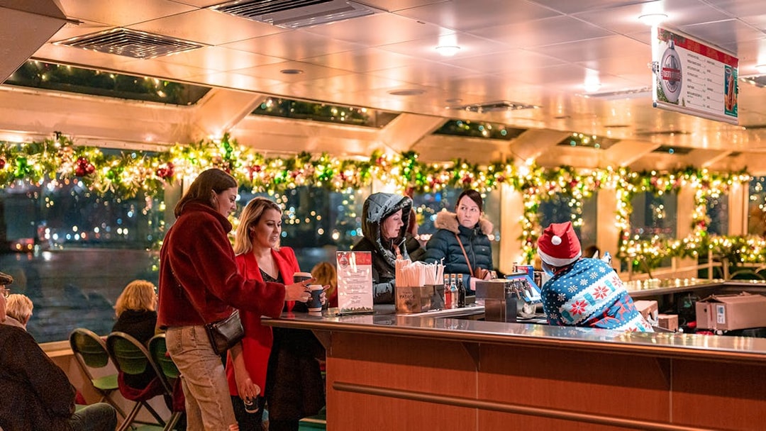 Guests enjoying drinks at a decorated bar on the Circle Line Harbor Lights Cruise.