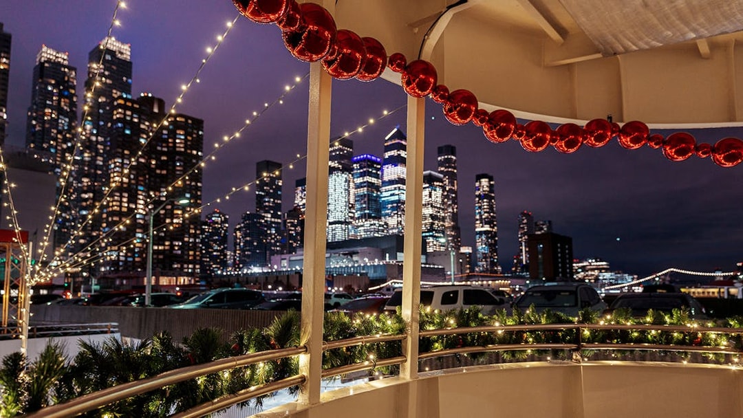 Harbor Lights Cruise with city skyline and festive decorations at night.