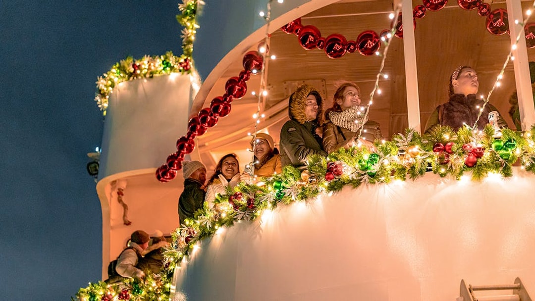 Passengers enjoy festive lights on Circle Line Harbor Lights Cruise.