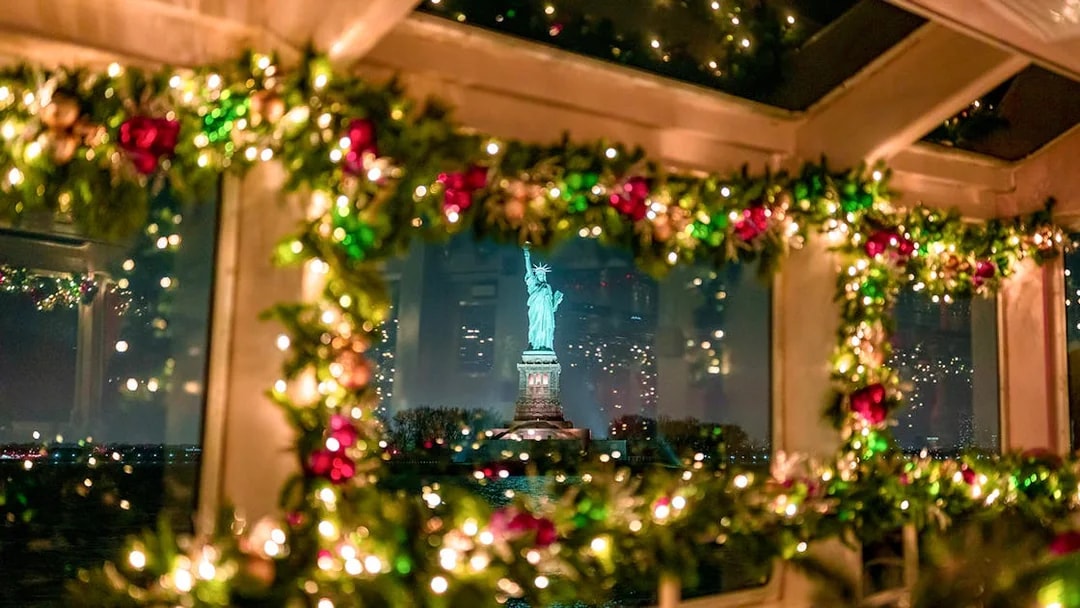 Statue of Liberty viewed through decorated cruise window at night.
