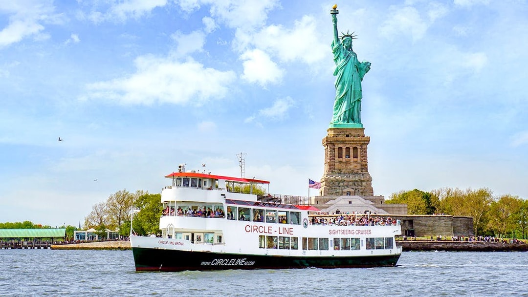 Sightseeing cruise boat near the Statue of Liberty in New York Harbor.