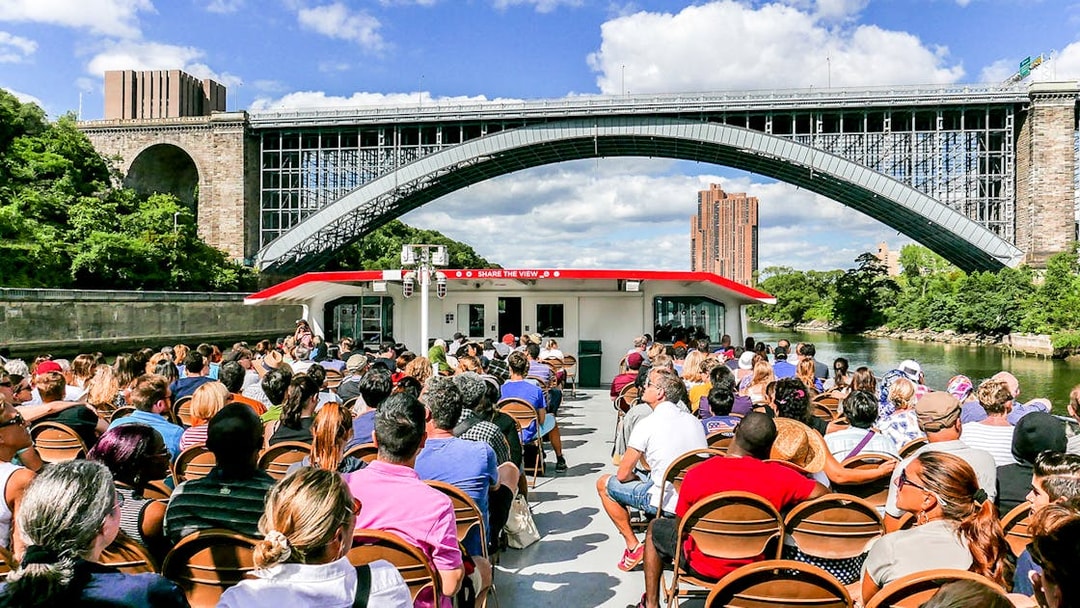 Passengers on a Circle Line cruise under a New York City bridge.