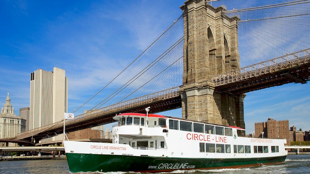 Cruise boat passing under Brooklyn Bridge on NYC landmarks tour.