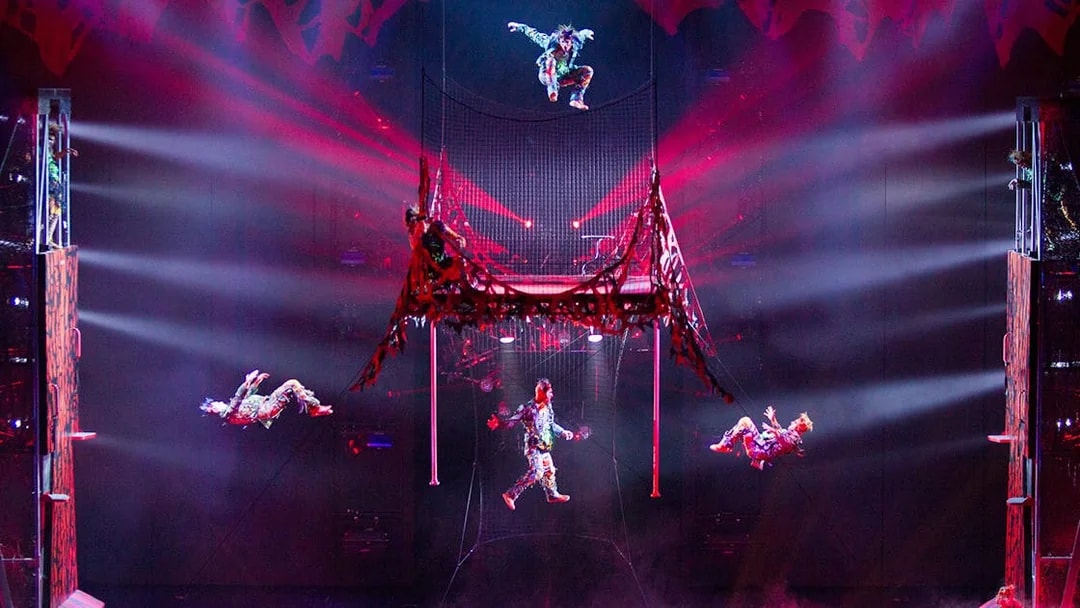 Acrobats performing in Michael Jackson ONE show with vibrant lighting effects.