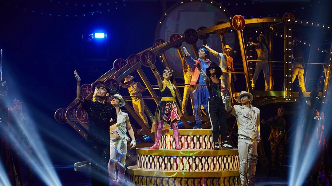 Performers on stage during Michael Jackson ONE show in Las Vegas, featuring vibrant costumes and dynamic poses.