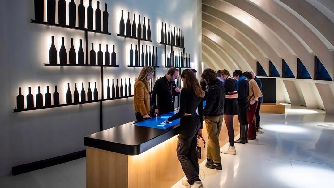 Visitors using interactive displays at Cité du Vin museum, Bordeaux, France.
