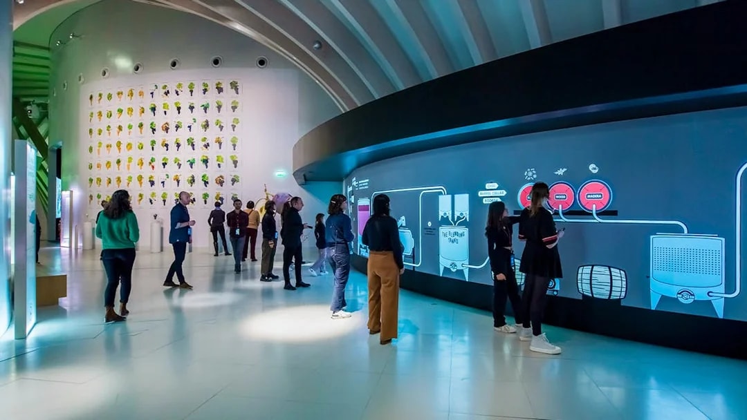 Visitors at Cité du Vin museum in Bordeaux on a self-guided audio tour with wine tasting.