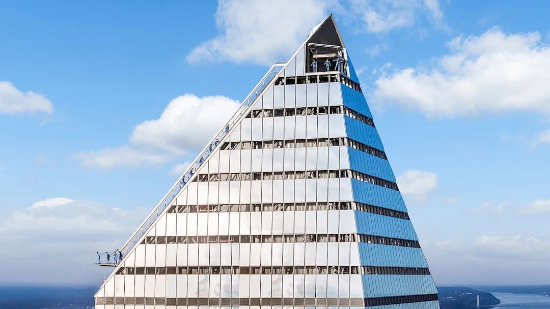 Climbers ascending the edge of a skyscraper during a City Climb Experience.