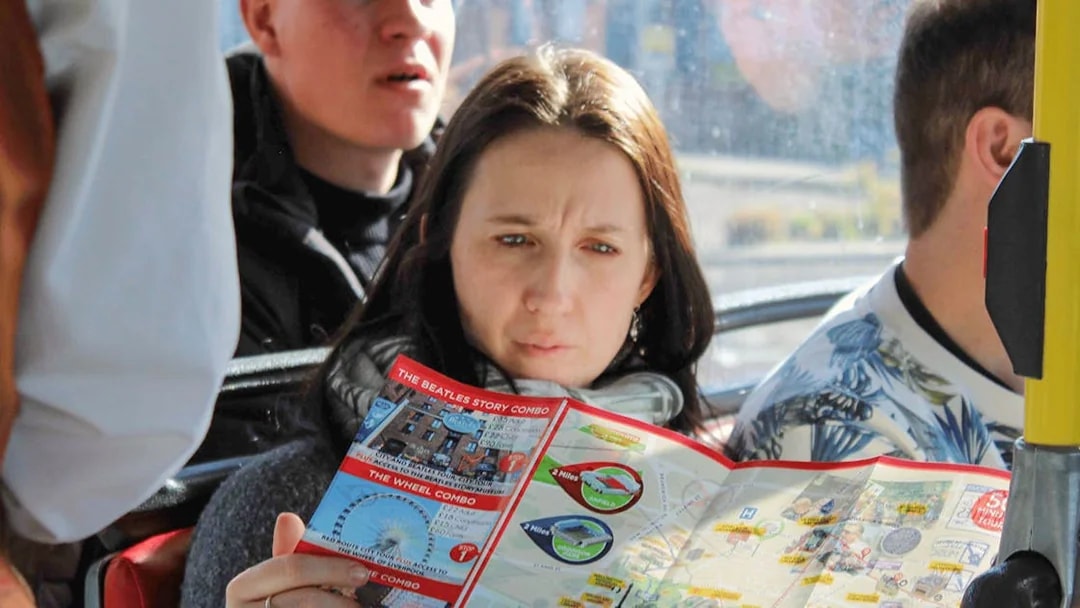 Woman reading map on Liverpool Hop On Hop Off city tour bus.
