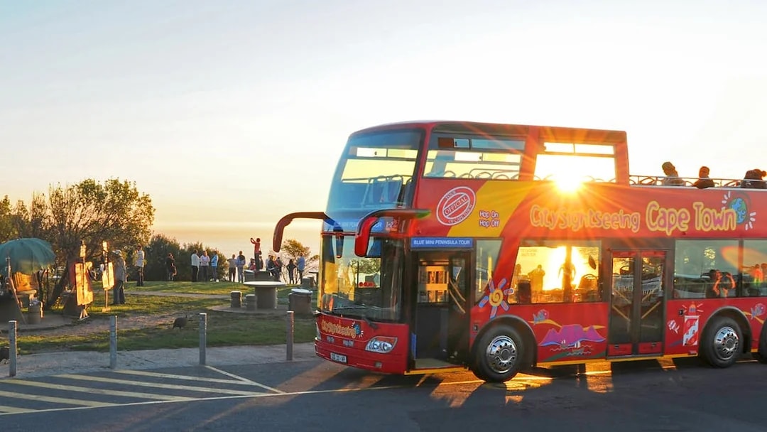 HopOn HopOff bus at sunset point, Cape Town, with tourists enjoying the view.
