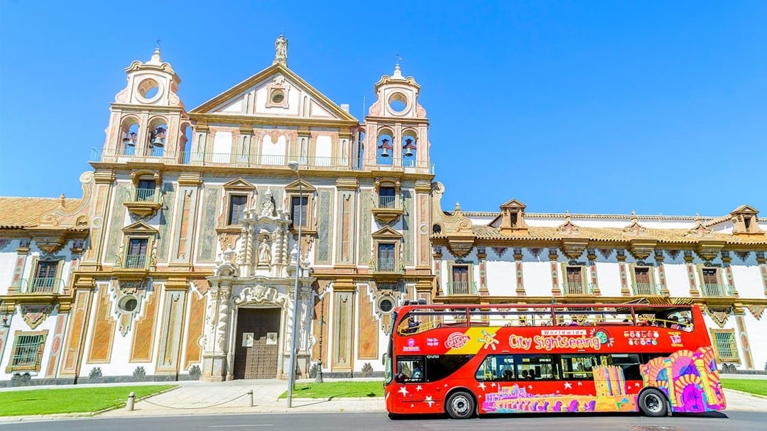 City sightseeing bus in front of historic building in Córdoba.