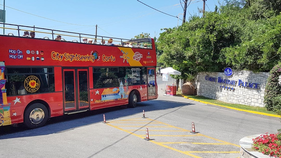 Red double-decker City Sightseeing bus near Corfu Holiday Palace entrance, Corfu.