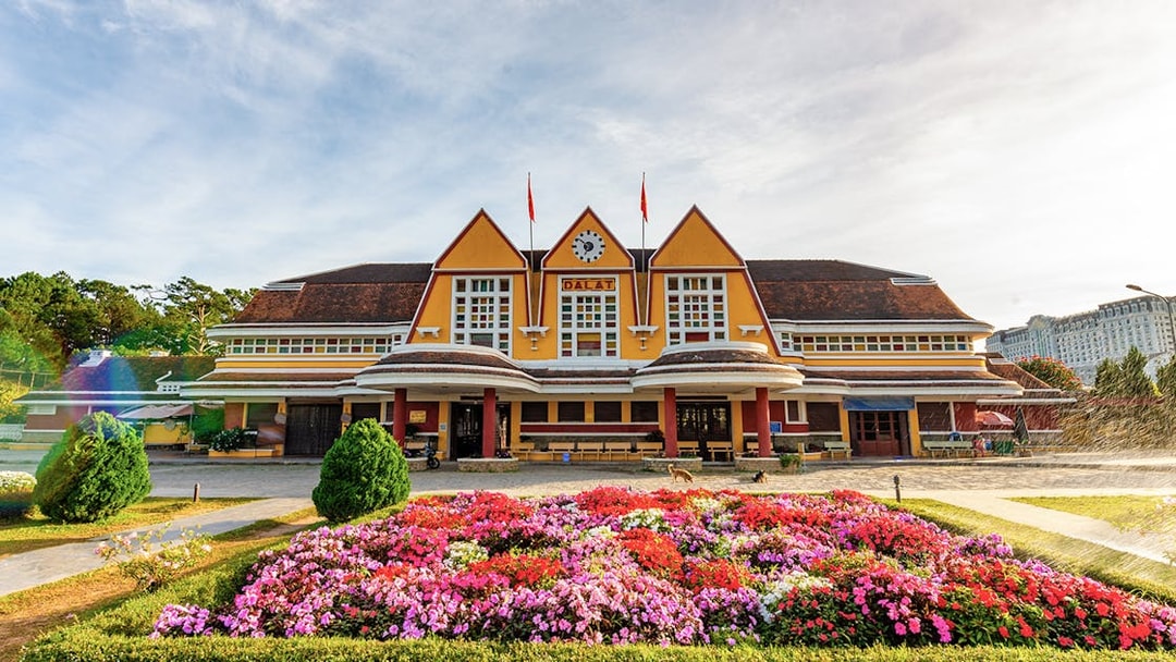 Dalat railway station with colorful flower garden in front.