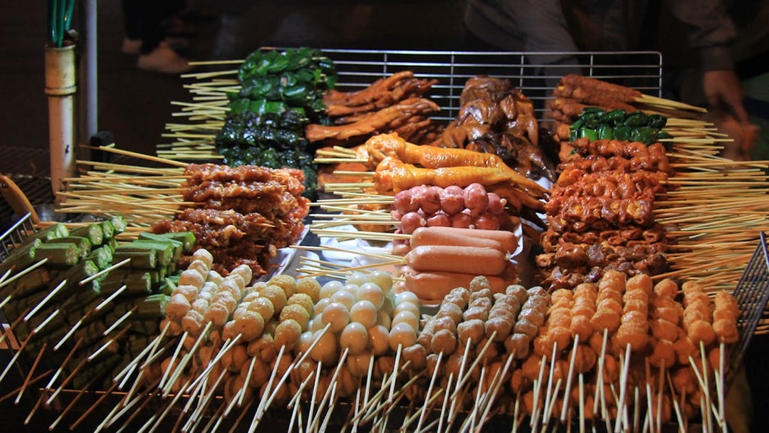 Skewers of various meats and vegetables at Da Lat night market food stall.