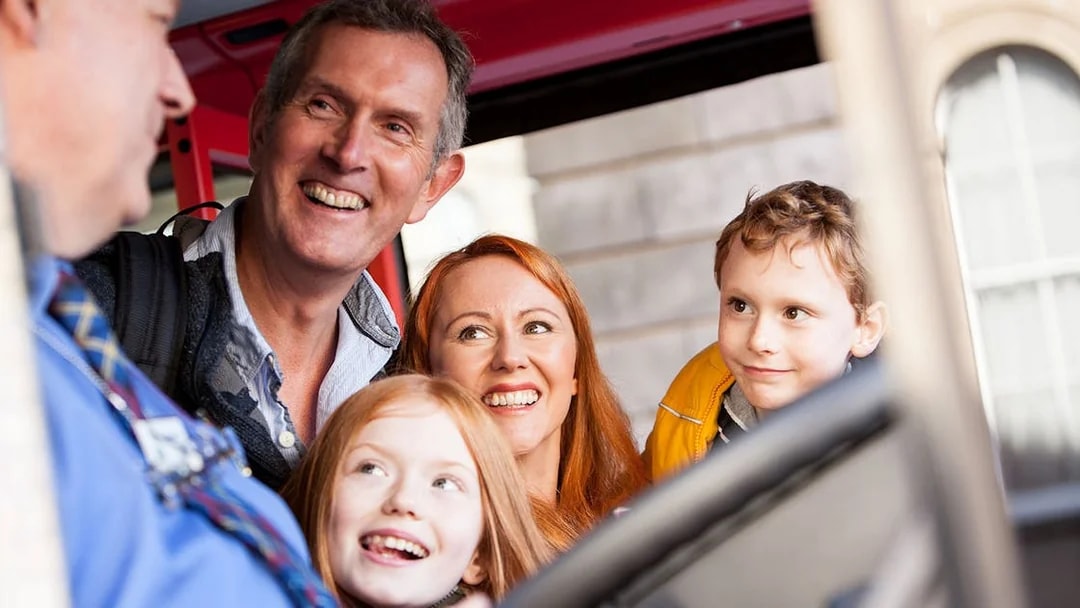 Family enjoying City Sightseeing Hop-On Hop-Off bus tour in Edinburgh.