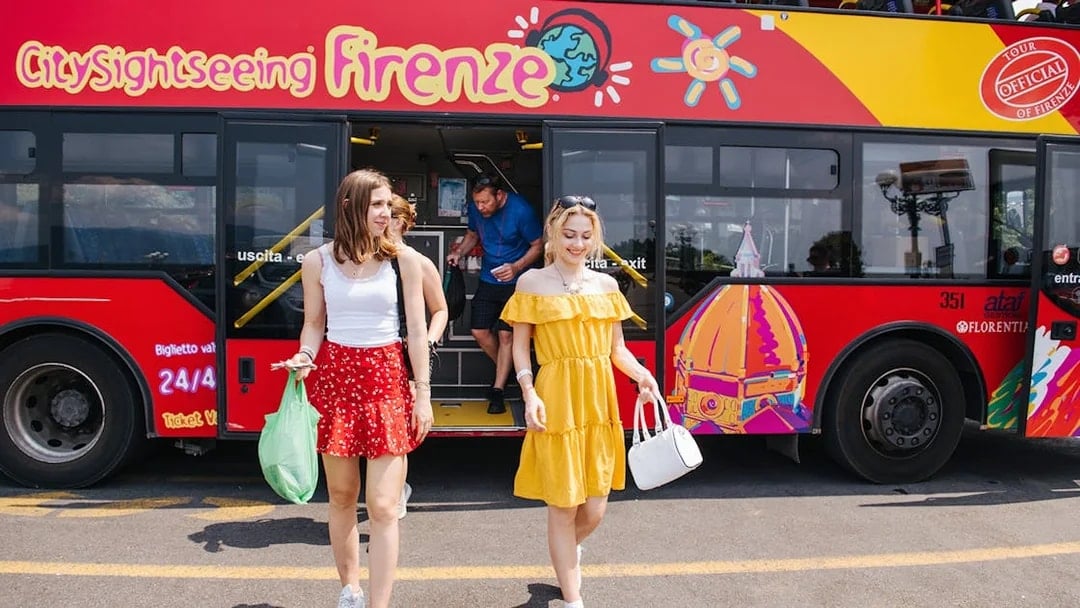Women walking by a CitySightseeing bus in Florence, Italy.