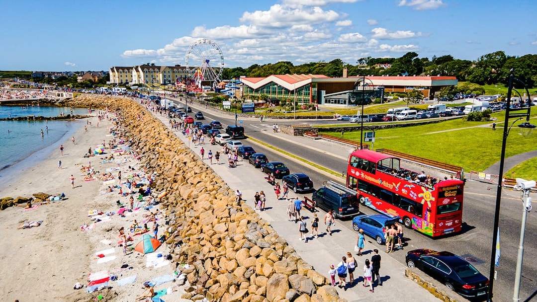 Double-decker bus on Galway Hop-On-Hop-Off Tour passing a busy beach.