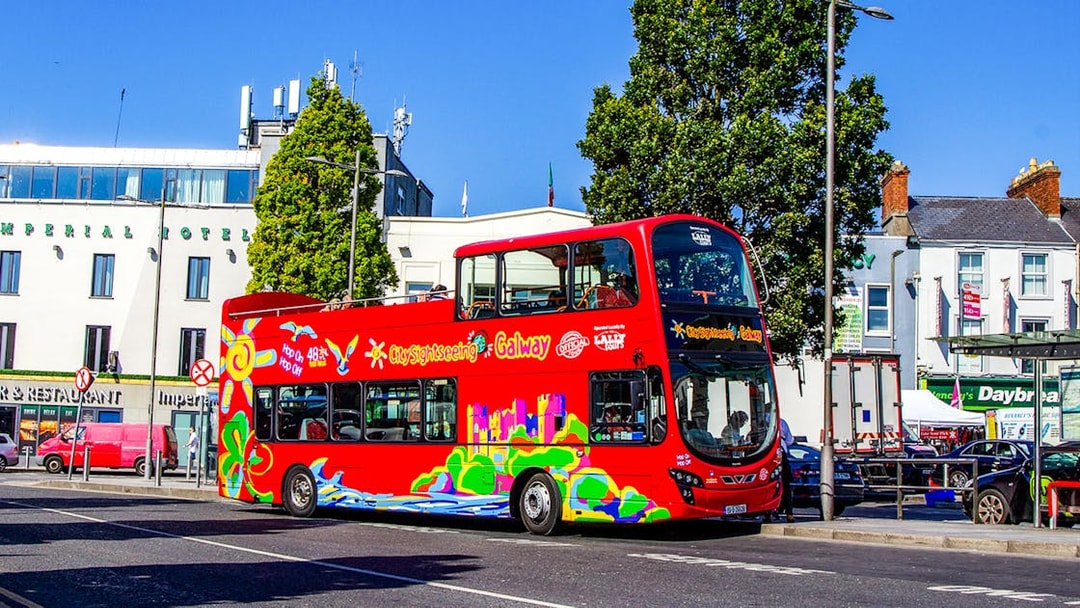 Red double-decker bus on Galway Hop-On-Hop-Off Tour near Imperial Hotel.