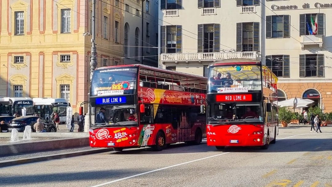 Hop-on hop-off tour buses in Genoa city center.