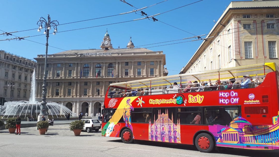 Open-top sightseeing bus in front of Palazzo della Regione, Genoa.