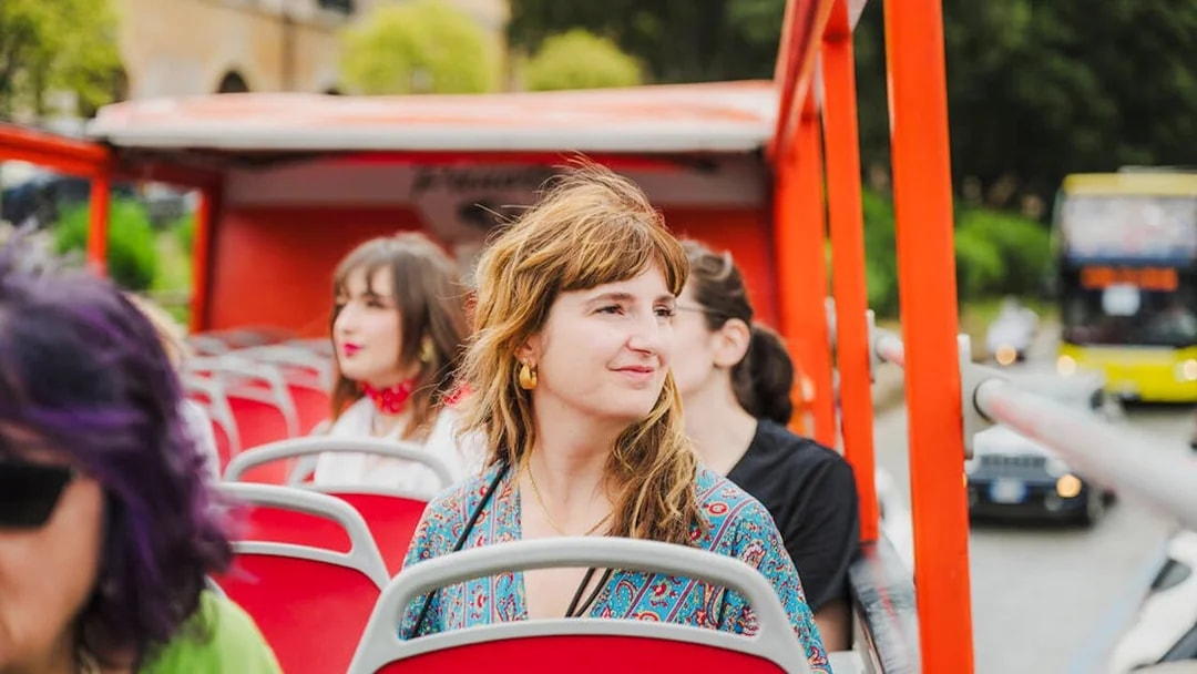 Sightseers on an open-top bus tour in Italy.