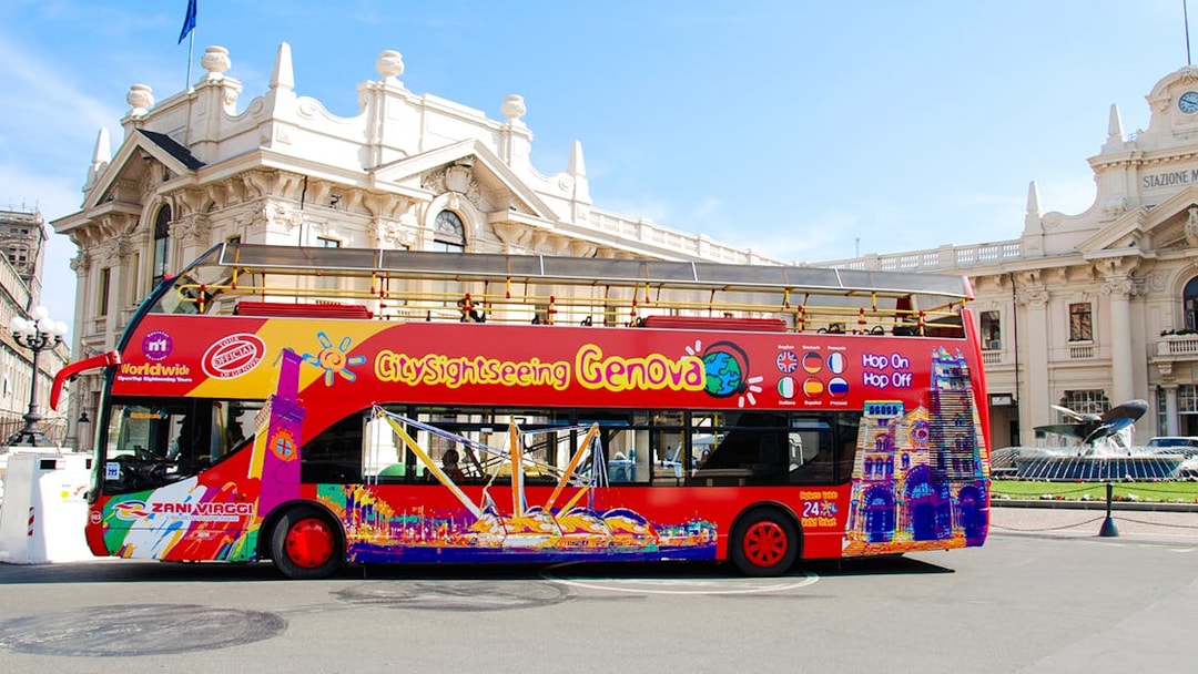 City Sightseeing Genova bus in front of historic building in Italy.