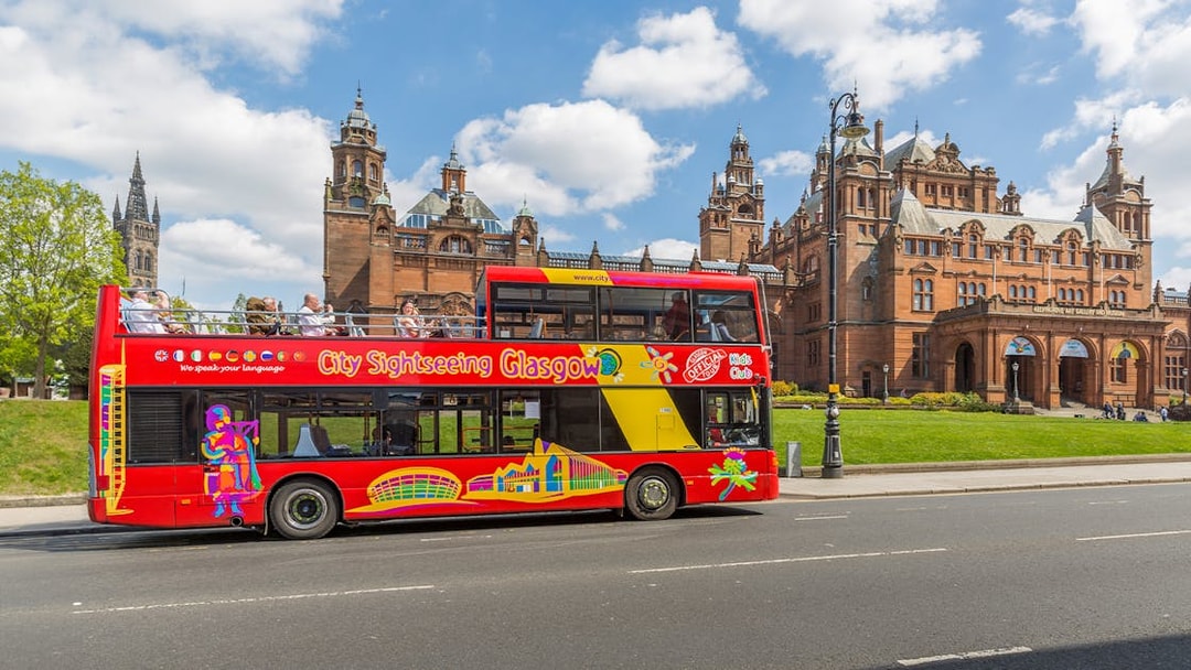 Open-top sightseeing bus in front of Kelvingrove Art Gallery, Glasgow.