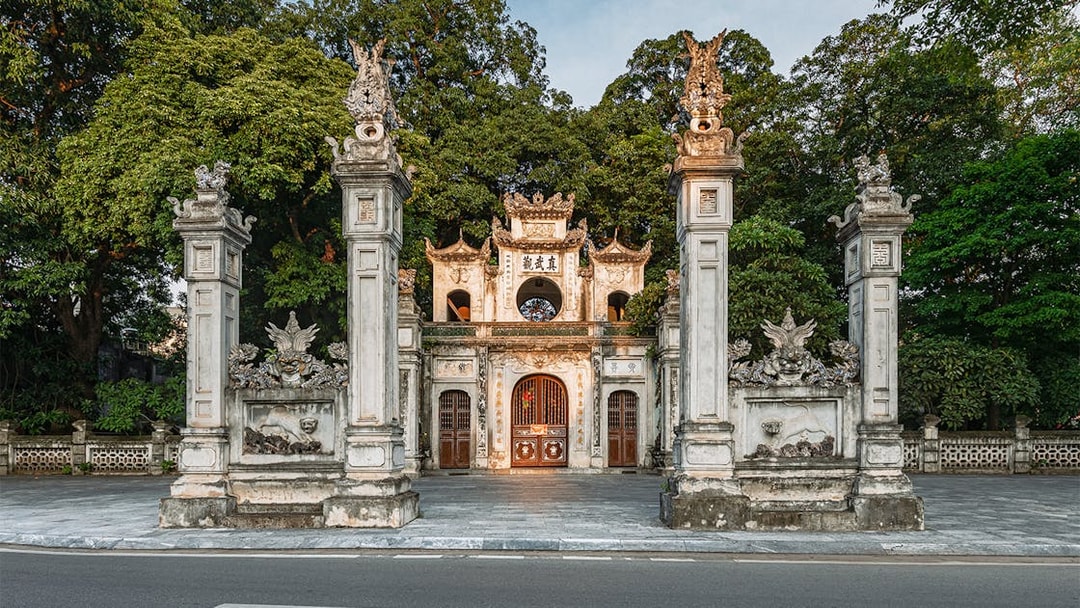 Quan Thanh Temple entrance in Hanoi, featuring ornate stone pillars and traditional architecture.