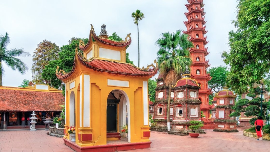 Tran Quoc Pagoda in Hanoi with traditional architecture and lush greenery.