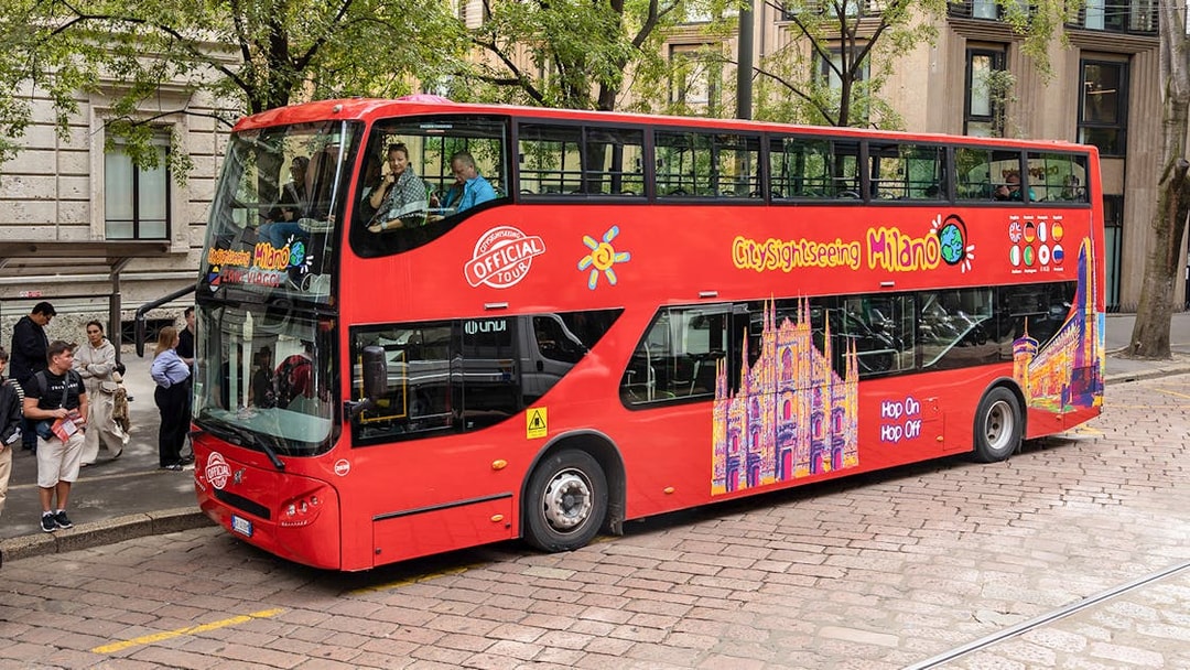 City Sightseeing Milan hop-on hop-off bus at a passenger stop.