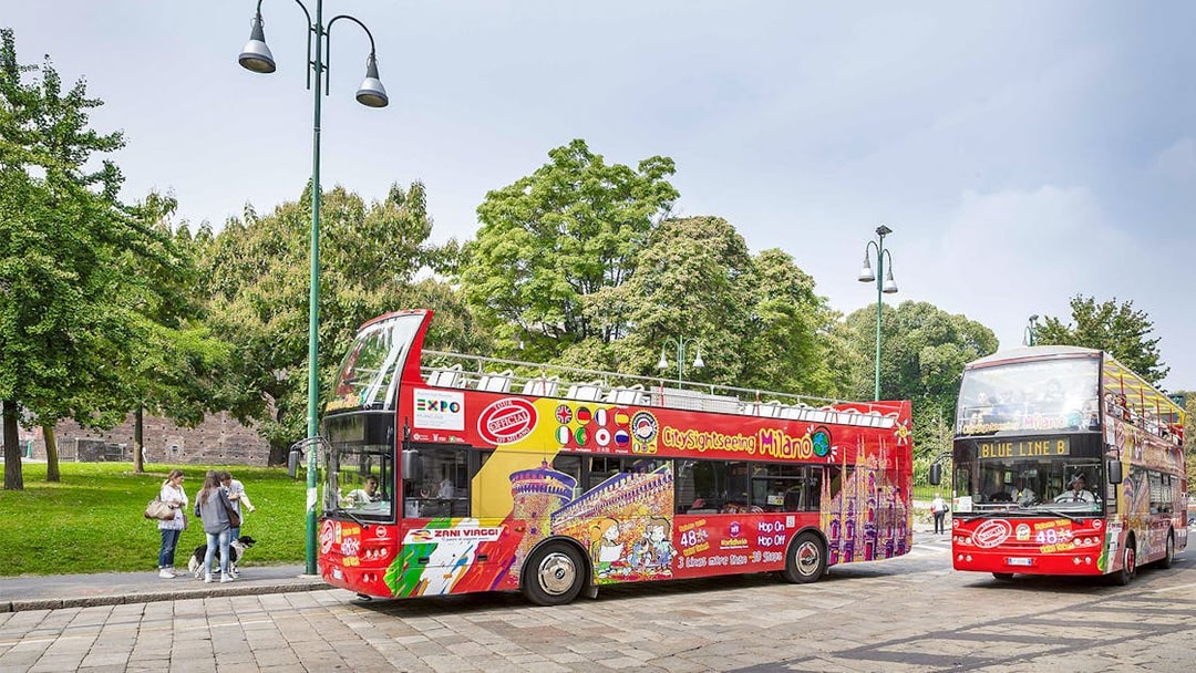 City Sightseeing Milan hop-on hop-off buses at a passenger stop.