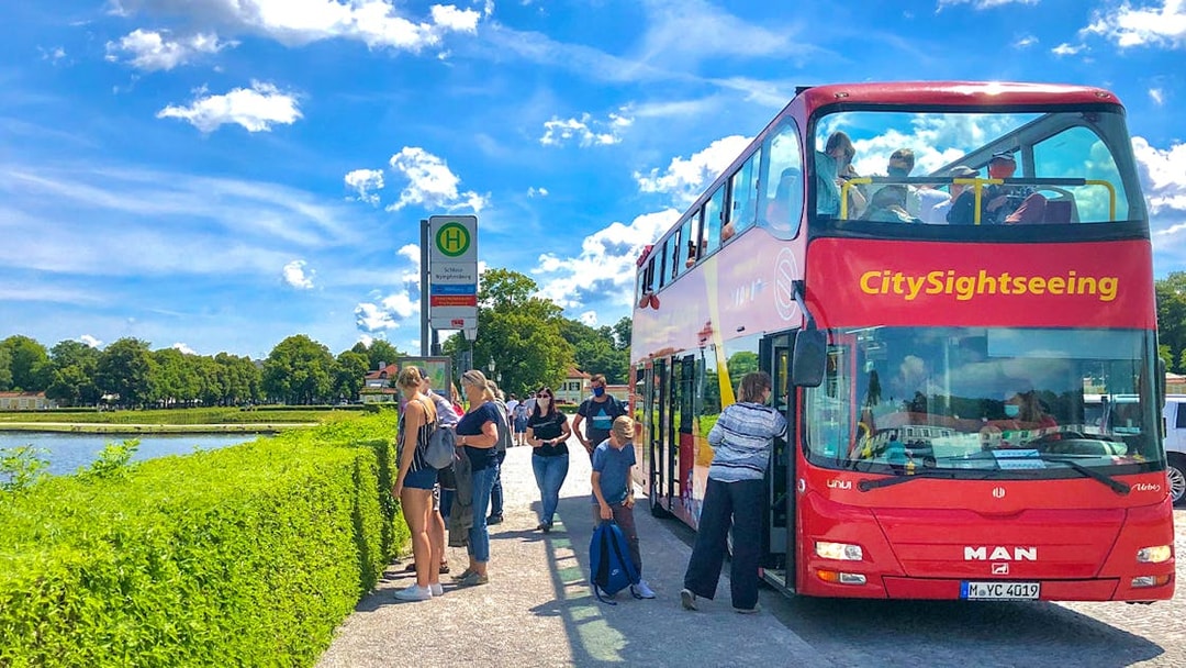 Tourists boarding Citysightseeing bus at Schloss Nymphenburg stop in Munich.