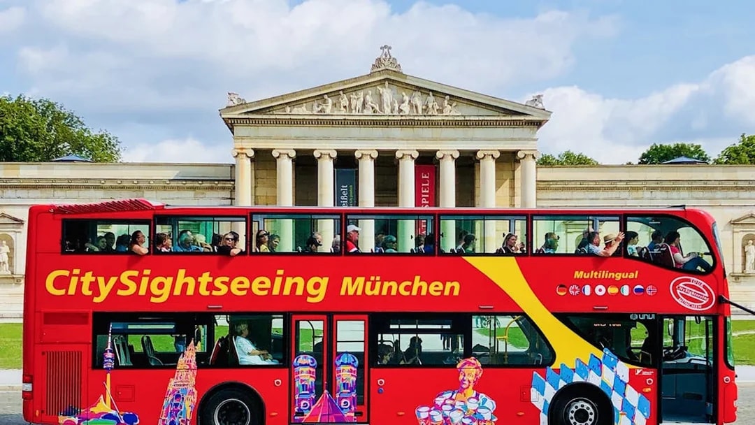 CitySightseeing bus in front of Munich's neoclassical building.