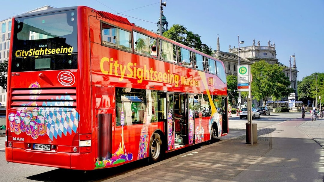 CitySightseeing bus in Munich near historic building.