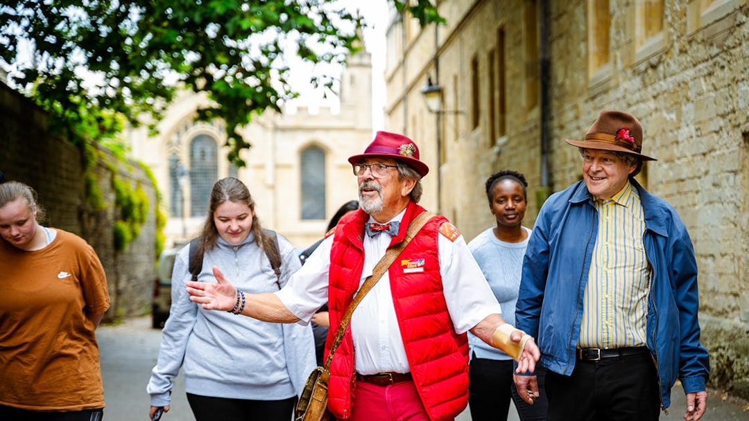 Guide leading tourists on a walking tour near historic buildings.