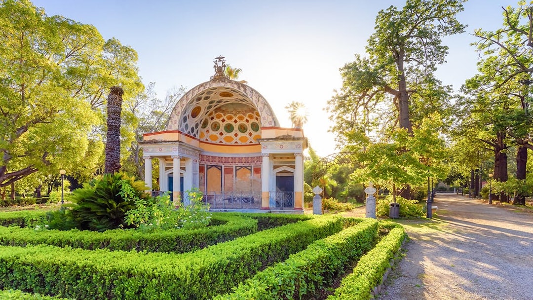 Ornate pavilion surrounded by lush greenery at Palermo Botanical Garden.