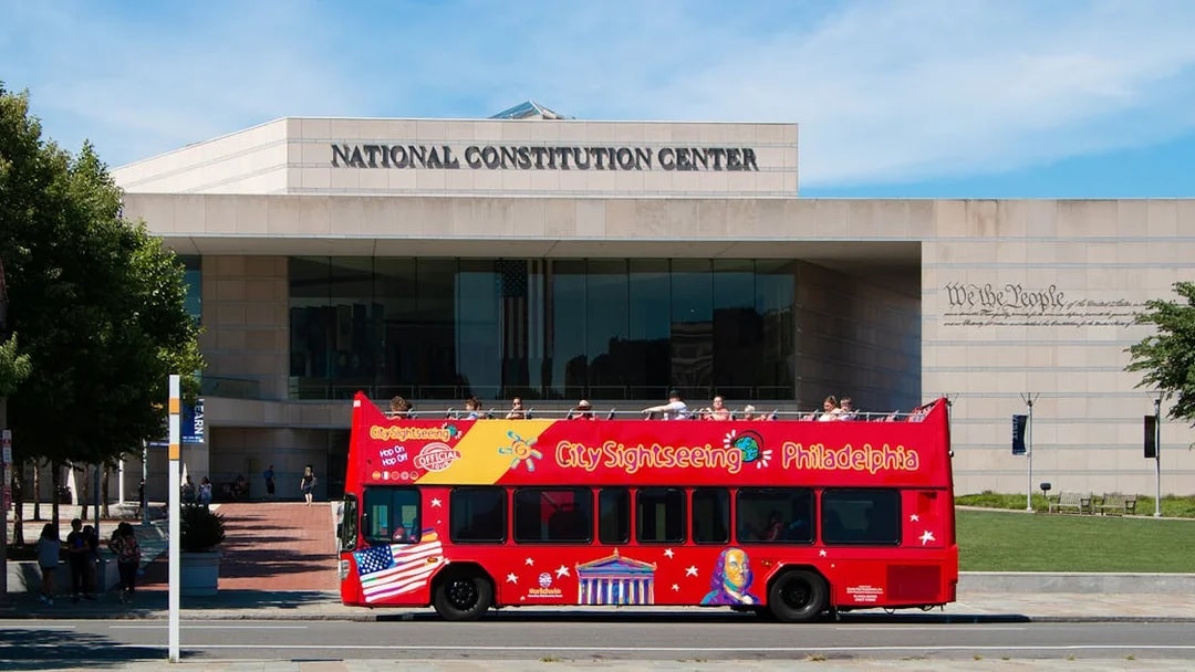 Red double-decker bus in front of the National Constitution Center, Philadelphia Hop-On-Hop-Off Tour.