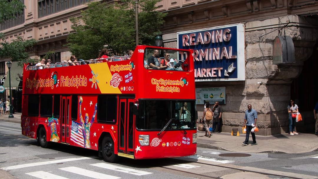 Red double-decker bus on Philadelphia Hop-On-Hop-Off Tour near Reading Terminal Market.