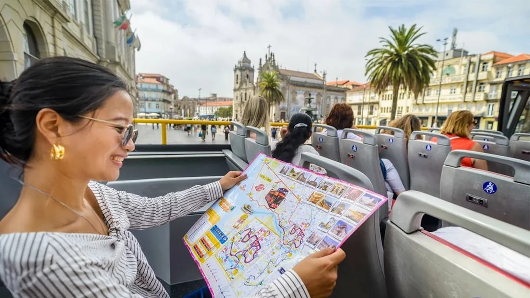 Woman reading map on Porto hop-on hop-off bus tour.