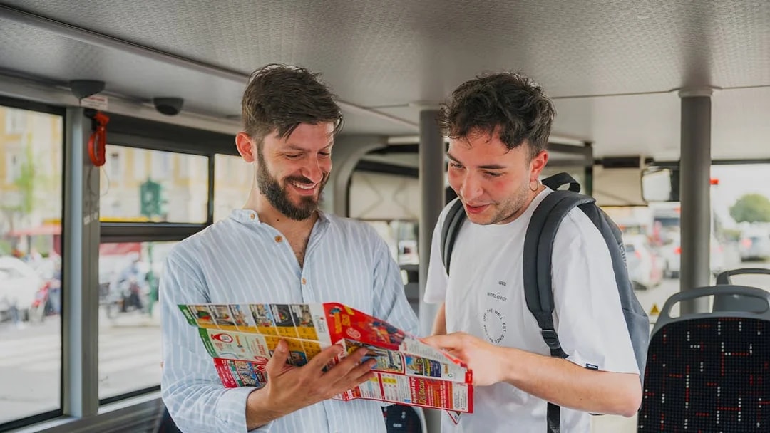 Tourists reading a map on a bus during a Rome night tour.