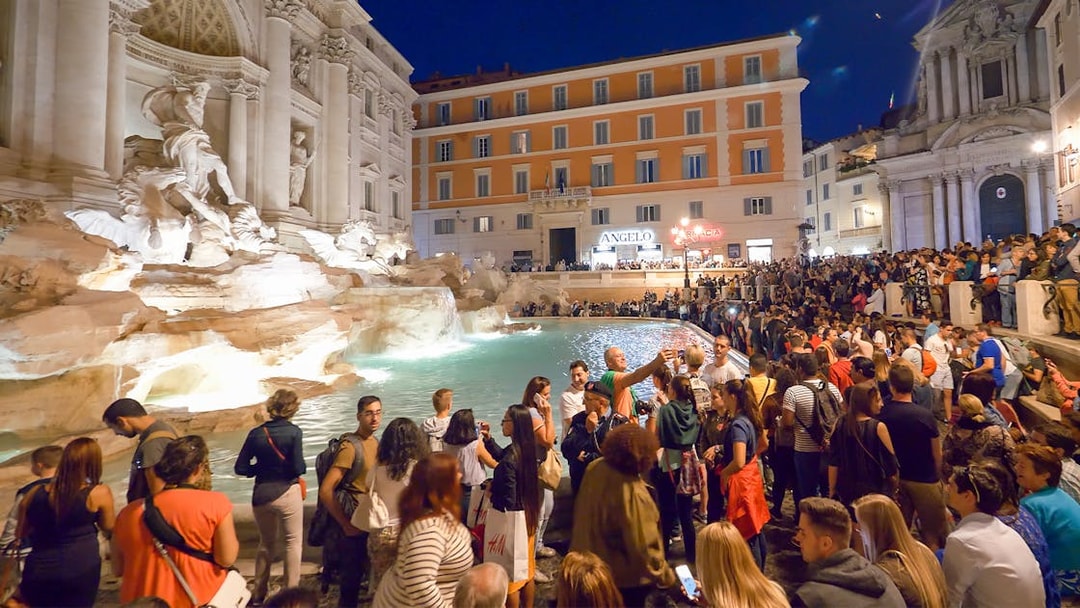 Crowd gathered at Trevi Fountain during Rome night tour.