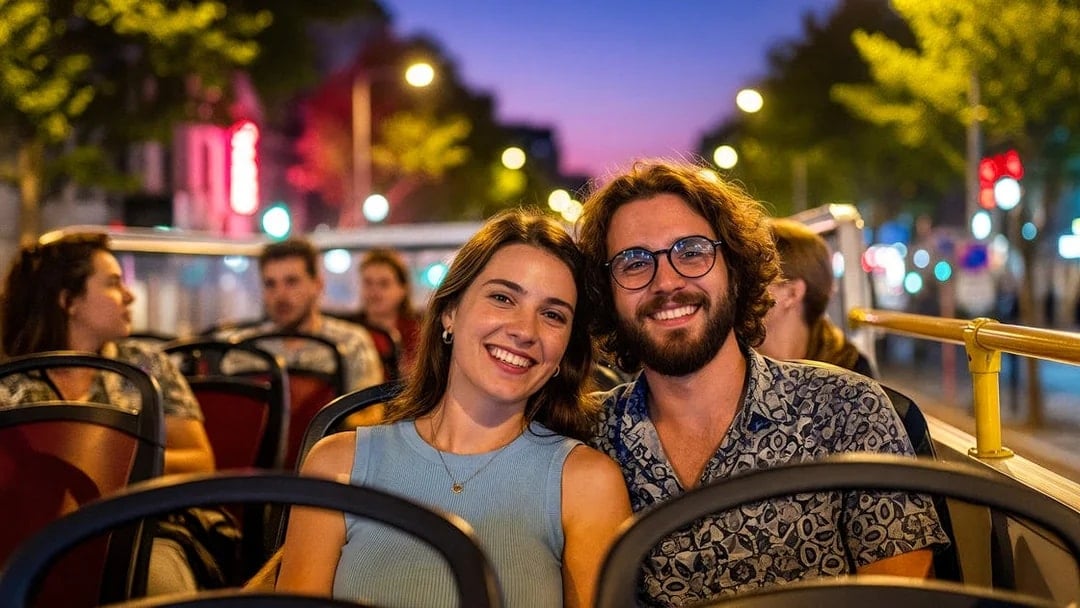 Tourists enjoying a city tour on a hop-on hop-off bus at dusk.