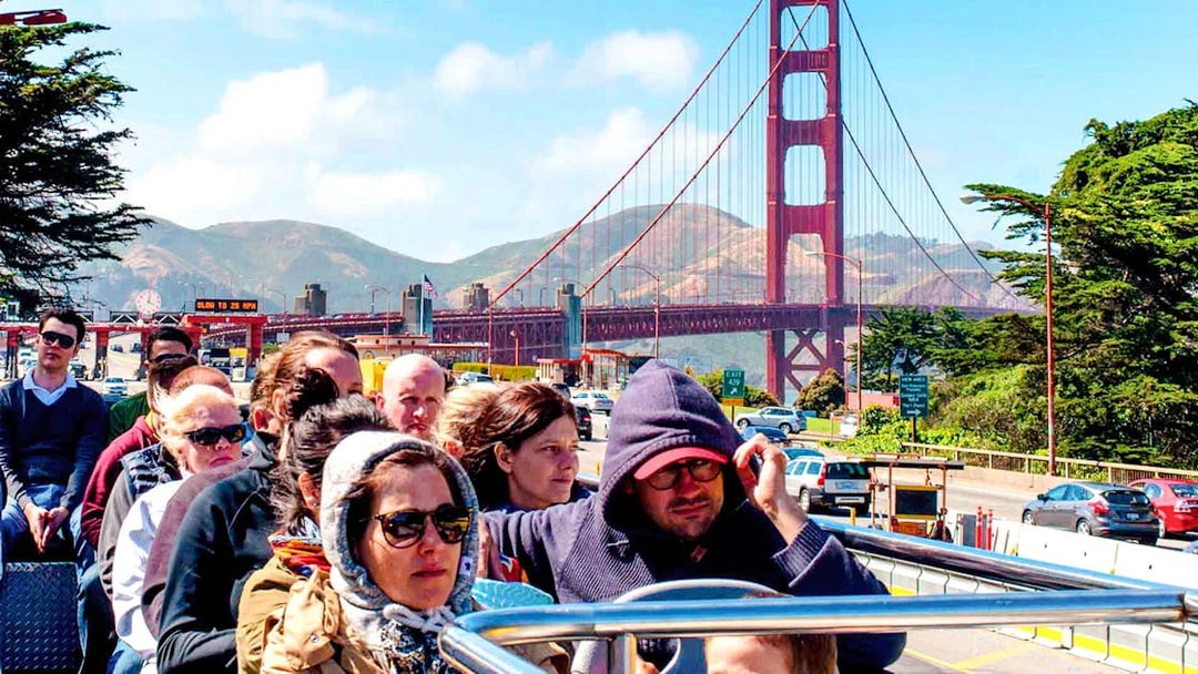 Tourists on open-top bus near Golden Gate Bridge, San Francisco.