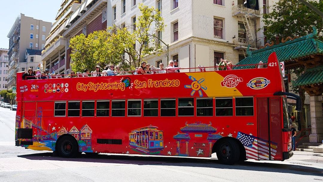 Open-top sightseeing bus in San Francisco with tourists on board.