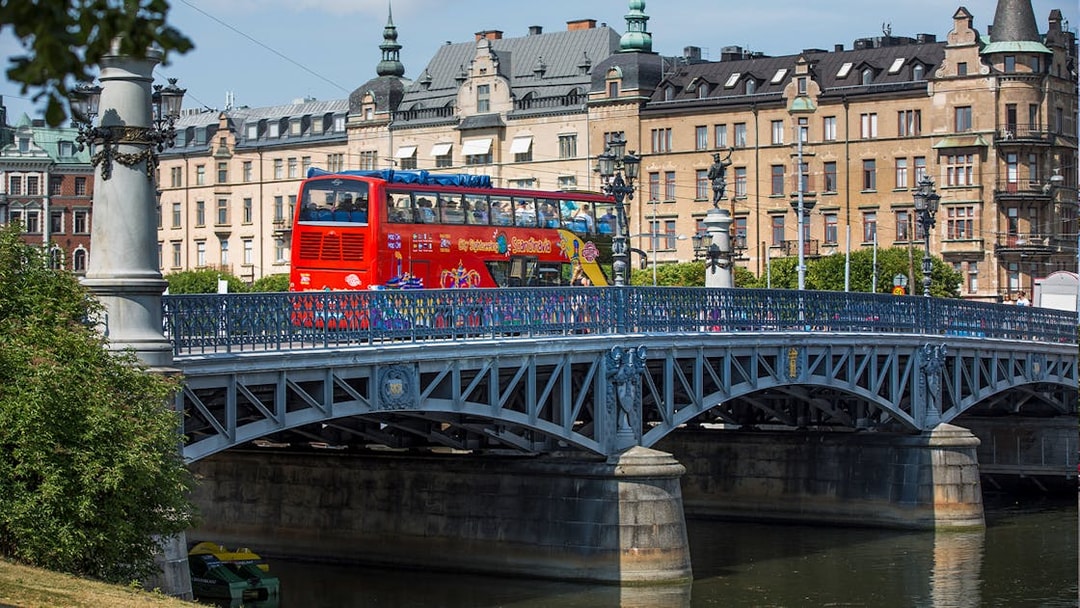 Red double-decker bus on a bridge in Stockholm during a Hop-On-Hop-Off tour.