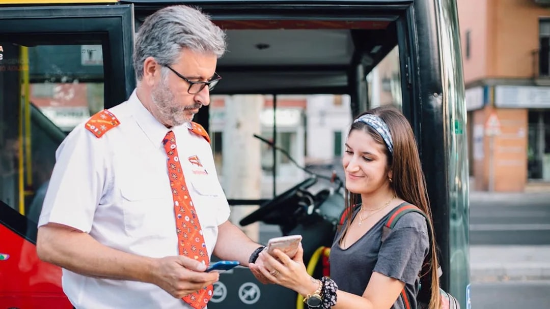 Bus driver assisting tourist with ticket on Thessaloniki Hop-On-Hop-Off Tour.