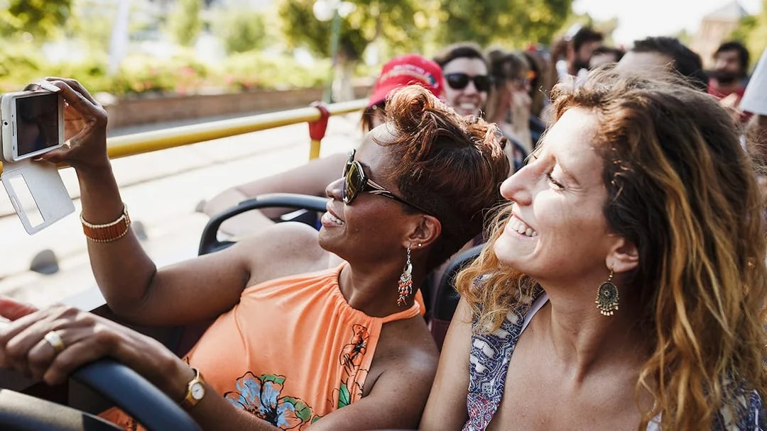Tourists enjoying Thessaloniki Hop-On-Hop-Off bus tour, taking photos.