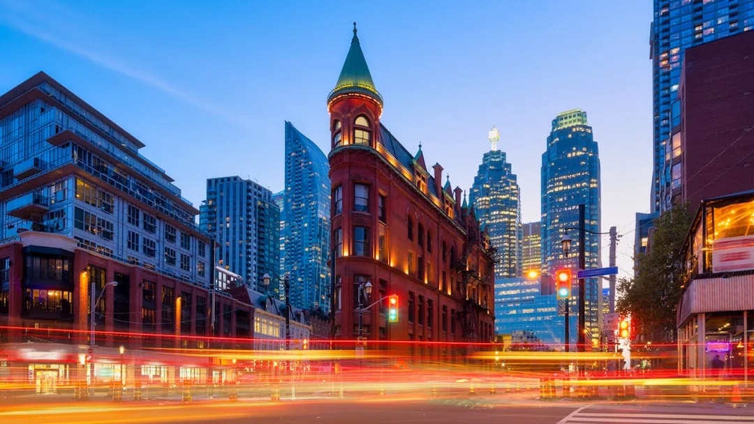 Gooderham Building with Toronto skyscrapers in the background at dusk.