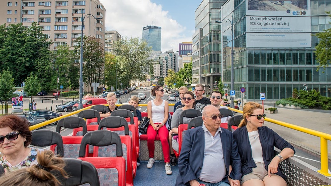 Passengers on an open-top bus tour in Warsaw city center, Poland.